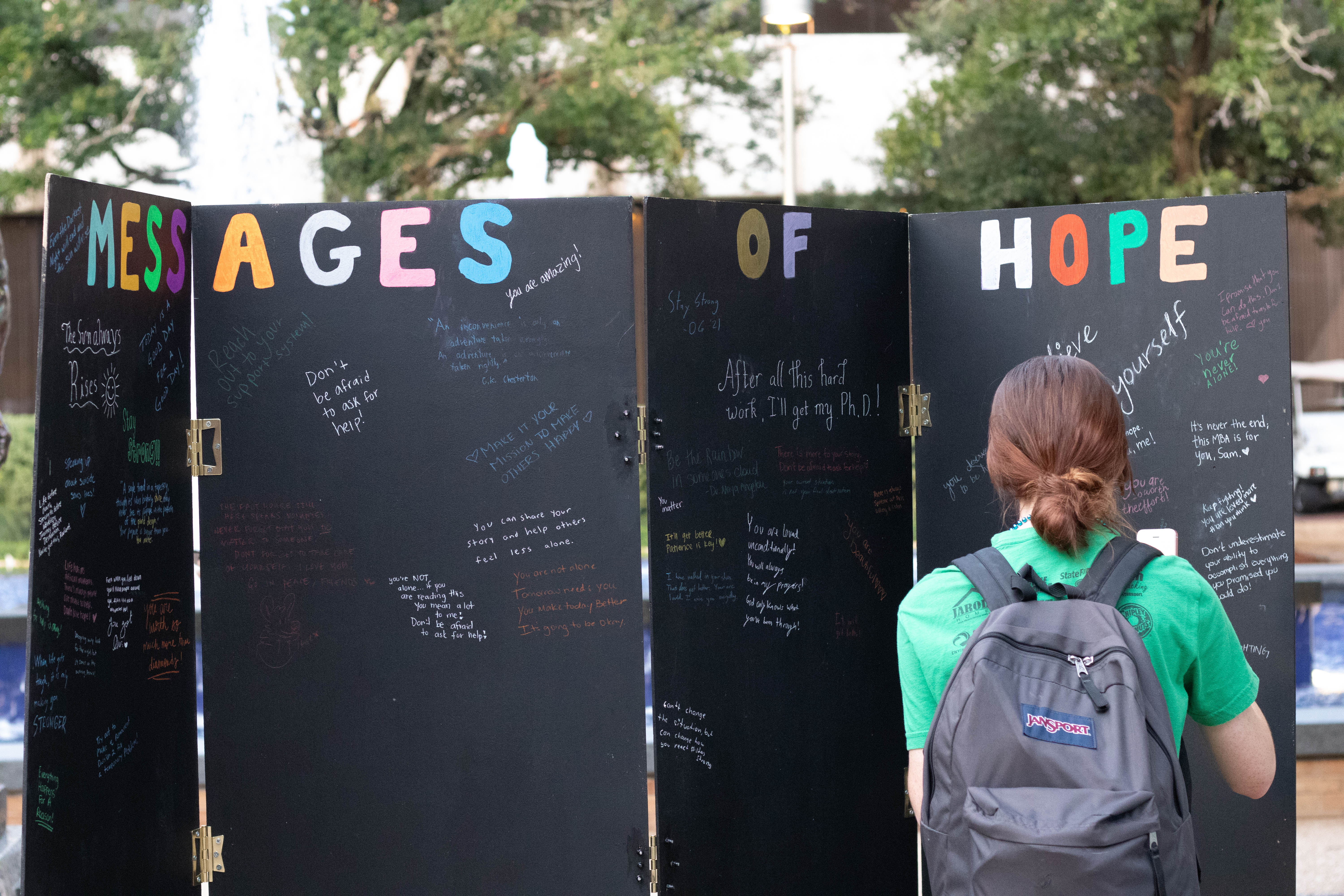 black Messages of Hope board with girl writing on it